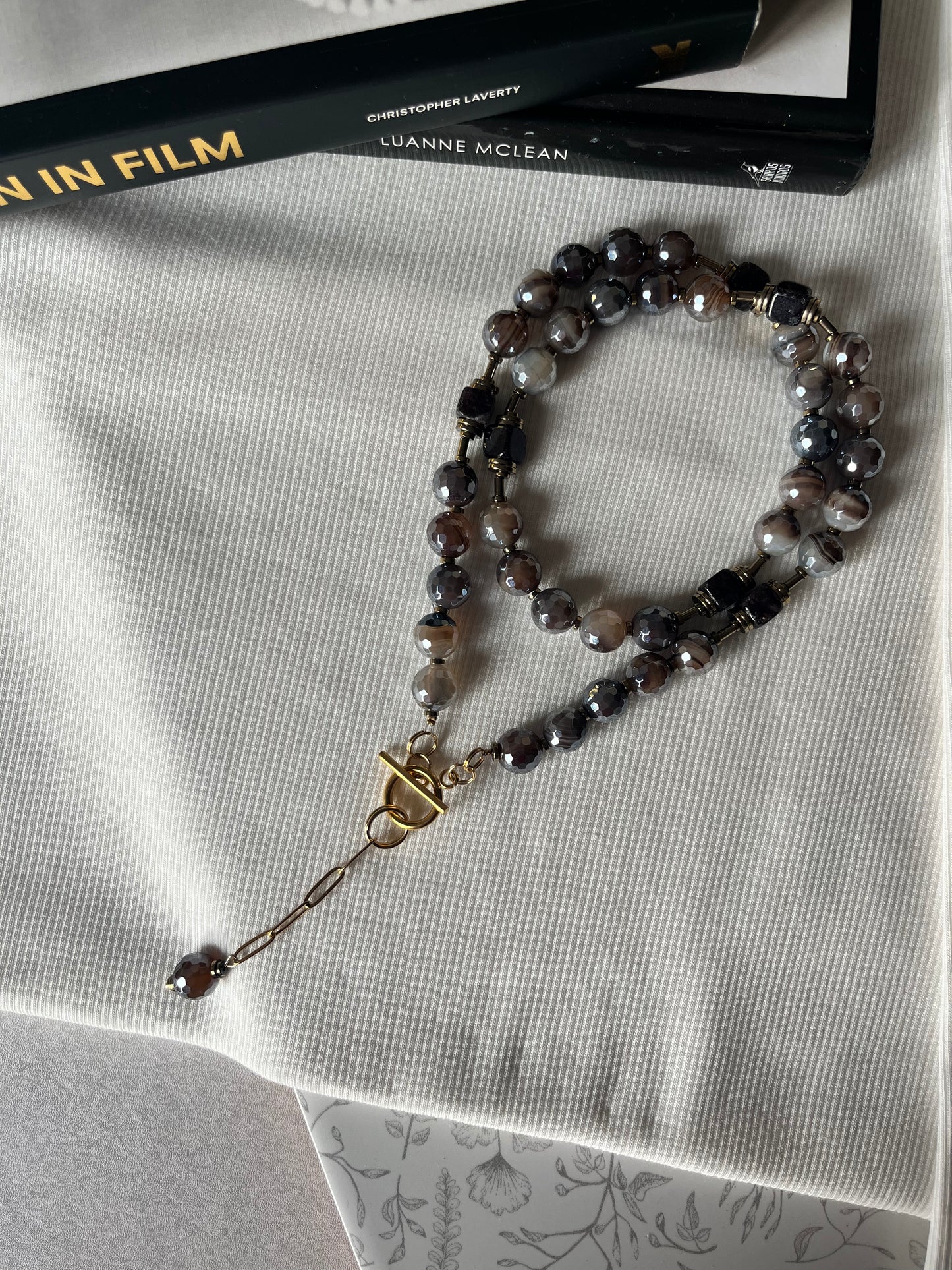 Rudos spalvos rankų darbo vėrinys iš dryžuoto agato.