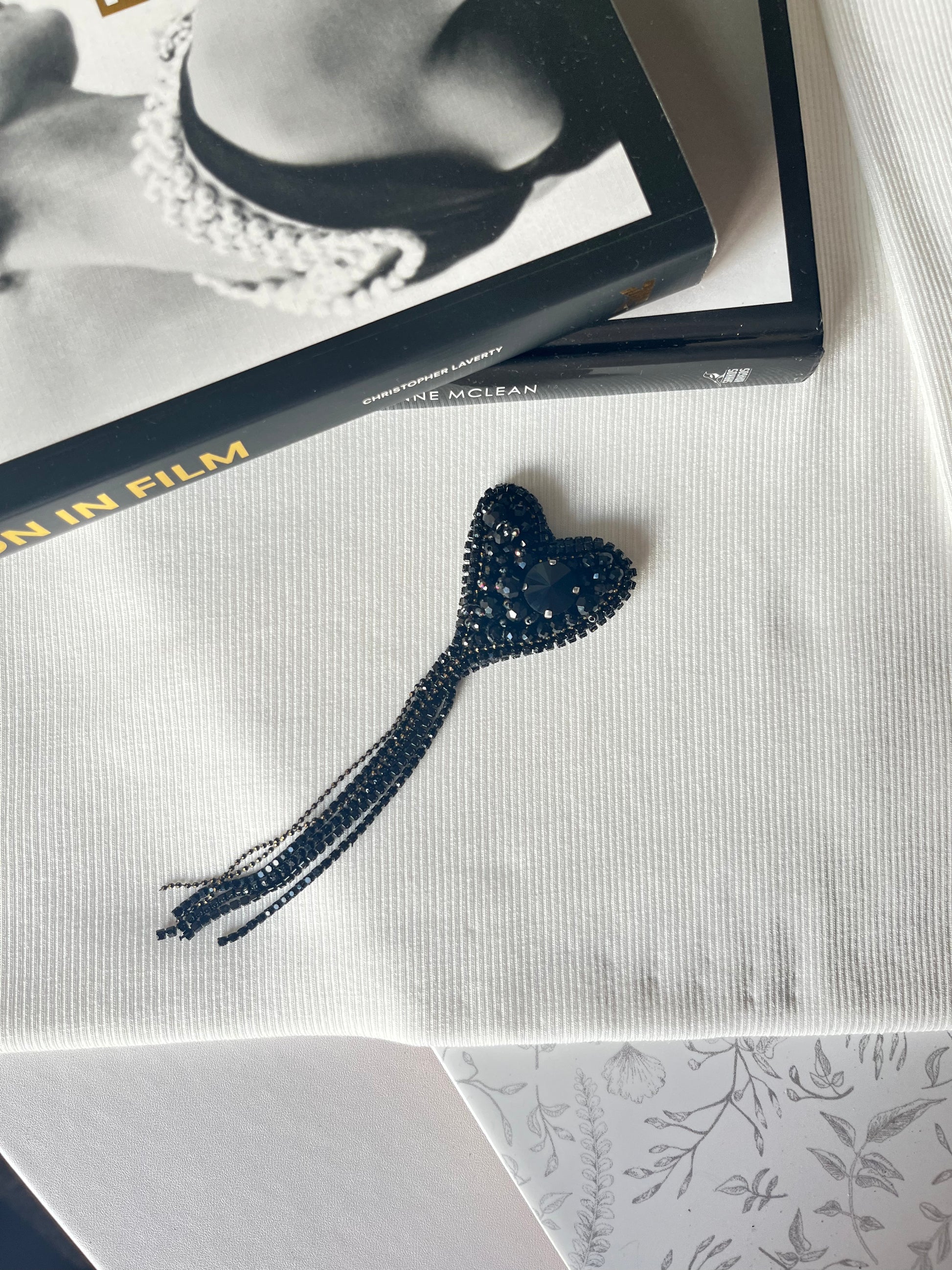 Juodos spalvos vienetinė rankų darbo sagė, siuvinėta karoliukais.