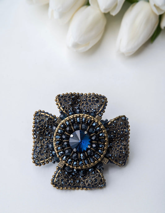 Rankų darbo vienetinė, mėlynos ir žalvario spalvos sagė.