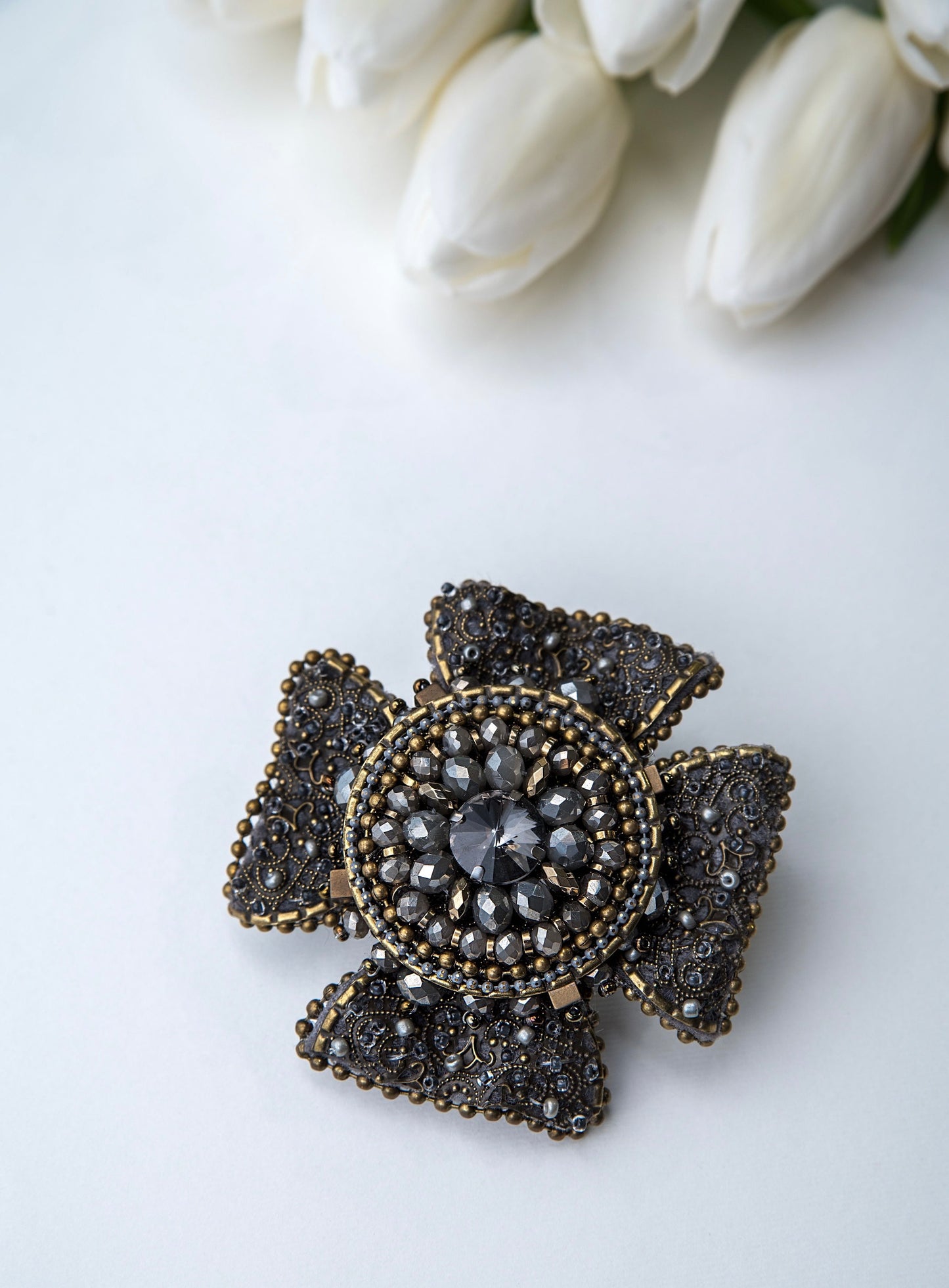 Rankų darbo vienetinė, pilkos ir žalvario spalvos sagė.