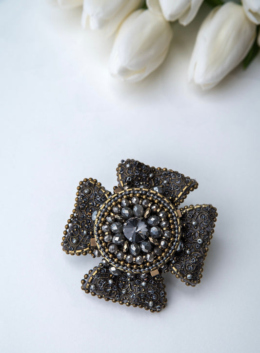 Rankų darbo vienetinė, pilkos ir žalvario spalvos sagė.