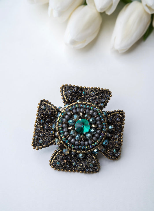 Rankų darbo vienetinė, žalios ir žalvario spalvos sagė.